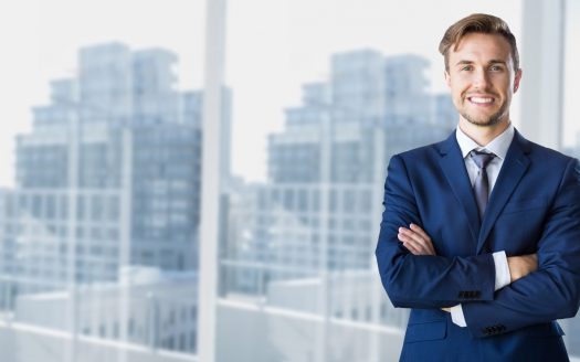 Businessman standing with arms crossed in office