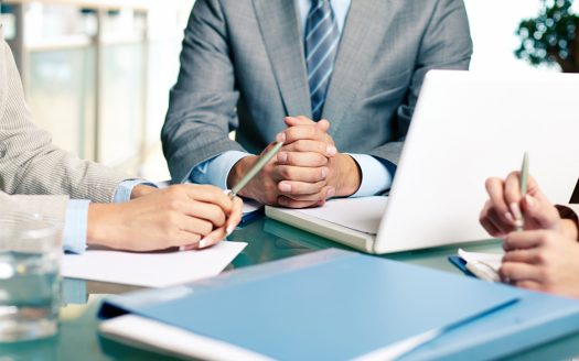 Close-up of hands of boss at workplace with laptop and hands of two females near by