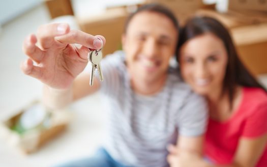 Hand of young man showing keys from new flat